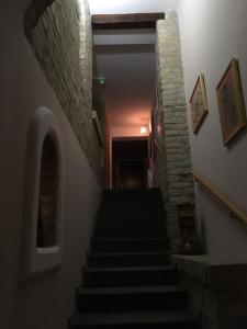 a staircase in a building with a stone wall at Guest House Prenoćište Piccolina in Sombor