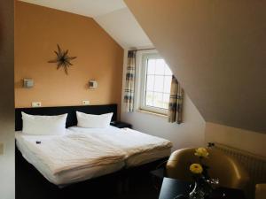 a hotel room with a bed and a window at Hotel Wuelfers Gasthaus in Groß Ippener