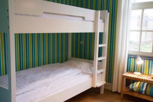 Ce lit superposé se trouve dans un dortoir aux murs verts. dans l'établissement 'Hof der Heerlijckheid', à Looz