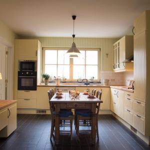 a kitchen with a table with chairs and a window at 'Hof der Heerlijckheid' in Borgloon