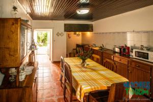 a kitchen with a table with a yellow table cloth on it at Hospedaria casa D'Avo in Praia da Vitória