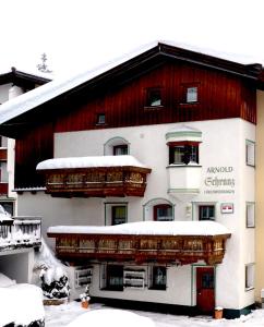 un grande edificio con la neve sopra di esso di Haus Arnold Schranz a Sankt Anton am Arlberg