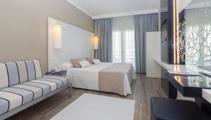 a hotel room with a bed and a couch at Canyelles Platja in Roses