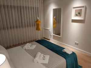 um quarto com uma cama e um espelho num quarto em Rafaelo's Apartment nas Caldas da Rainha