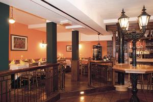 a bar in a restaurant with tables and chairs at Hotel zur Krone in Hameln