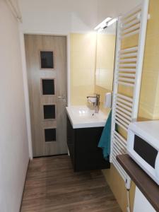 a bathroom with a sink and a microwave at Apartmány pod Divadlem in Znojmo