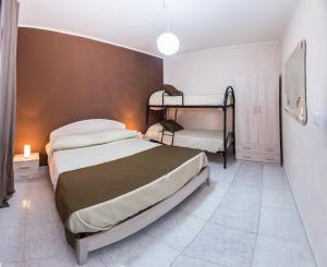 a bedroom with two beds and two bunk beds at Serenedad Casavacanza Torre Lapillo in Torre Lapillo