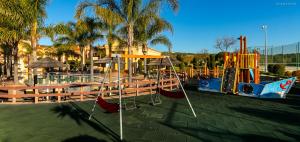 a playground with a slide and a swing set at LuzBay Pool Apartments in Luz