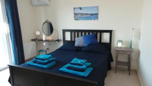 een slaapkamer met een bed met blauwe handdoeken bij Villa Finiki Messinia upstairs in Foiníki