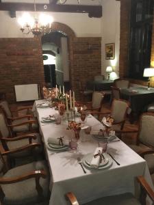 a table in a restaurant with a white table cloth at Guest House Prenoćište Piccolina in Sombor