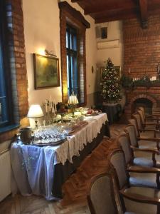 a dining room with a table and a christmas tree at Guest House Prenoćište Piccolina in Sombor