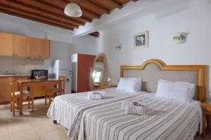 una camera da letto con un grande letto con due cuscini sopra di Adonis Rooms a Kalo Livadi
