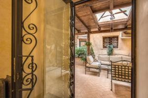 Une porte ouverte s'ouvre sur une terrasse avec une table et des chaises. dans l'établissement Residenza San Calisto, à Rome