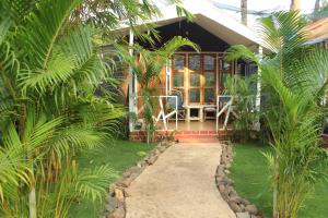 a house with palm trees in front of it at Sea Shades Palolem Resort in Palolem