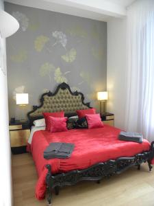 Un dormitorio con una gran cama roja con almohadas rosas en Gelsomino 74, en Florencia