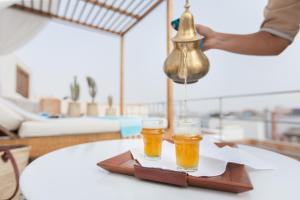 two glasses of beer are sitting on a table at Riad Emotion in Essaouira