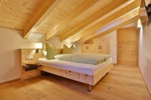 una camera con letto in una stanza con soffitti in legno di Arvenhof a Serfaus