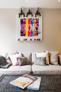 Sleek Arty Apartment في لندن: غرفة معيشة مع أريكة مع لوحة على الحائط