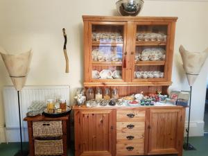 a wooden cabinet with dishes in it at The Spindrift Guest House in Anstruther