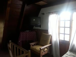 Habitación con silla, TV y ventana en Freecis en Esquel