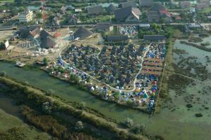an aerial view of a village next to a river at Dolphin Camping in Sfântu Gheorghe
