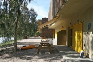 un grupo de mesas de picnic sentadas fuera de un edificio en Apartamentos Villa Vacacional, en Castuera