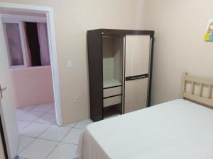 a bedroom with a closet with a bed and a mirror at Casa para verão em Balneário Gaivota in Balneário Gaivotas