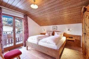 a bedroom with a large bed with a wooden ceiling at Landhaus Wankleiten in Bad Hindelang