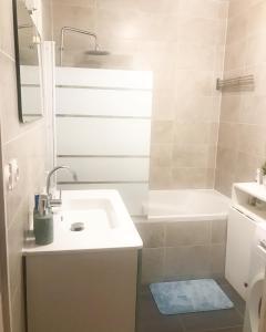 bagno bianco con lavandino e doccia di Cosy 74m2 apartment close to Paris a Houilles