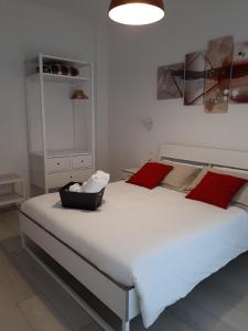 a bedroom with a large white bed with red pillows at SoleLuna Fiera 6 Rooms in Bologna