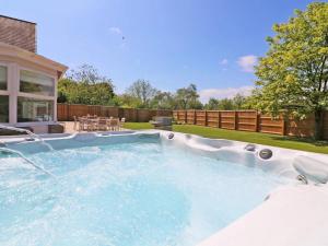 
a swimming pool with a pool table and chairs at Waterside Cornwall in Bodmin

