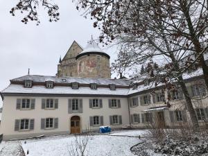a building with a tower on top of it in the snow at Manoir de la Côte-Dieu in Porrentruy
