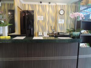 ジャカルタにあるTwins Hotelのバスルーム(壁に時計付きのカウンター付)
