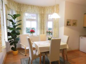a dining room with a table and chairs and windows at Ferienwohnung Zum Lilienstein in Bad Schandau