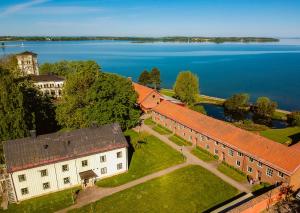 eine Luftansicht eines Gebäudes neben einem See in der Unterkunft Vadstena Folkhögskola Vandrarhem in Vadstena