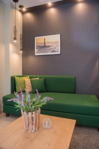 a green couch in a living room with a table at Sokratis Hotel in Nea Moudania