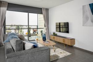 uma sala de estar com um sofá e uma televisão em Luxurious flat in residential area em Jerusalém