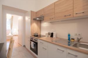 a kitchen with white cabinets and a sink at Vienna Living Apartments - Schnirchgasse in Vienna