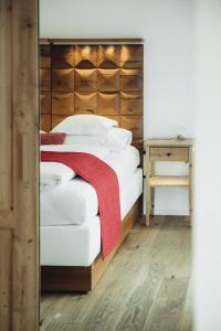 a bedroom with a bed with a wooden headboard at Mooser Hotel in Sankt Anton am Arlberg