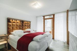 a bedroom with a large bed with a wooden headboard at Mooser Hotel in Sankt Anton am Arlberg