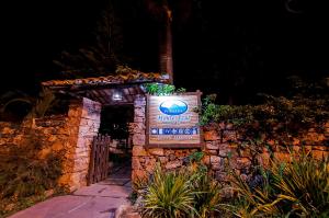 a sign for the entrance to a resort at night at Pousada Monte Azul in Mucugê