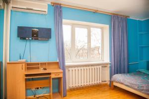 ザポリージャにある2Room Semi-luxury Apt on Stalevarov 21の青い壁のベッドルーム(ベッド1台、デスク付)