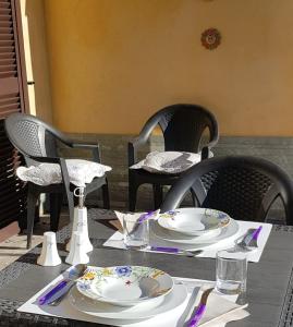 a table with plates and utensils on top at Appartamento Malpensa Rho in Samarate