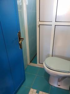 La salle de bains est pourvue de toilettes et d'une porte bleue. dans l'établissement Gite Kasbah La Palmeraie, à Skoura