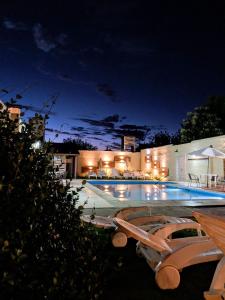 a swimming pool at night with two lounge chairs next to it at Casablanca Hotel & Spa in Santa Rosa de Calamuchita