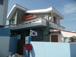 a house with a fence in front of it at Guesthouse Spring Flower in Seogwipo