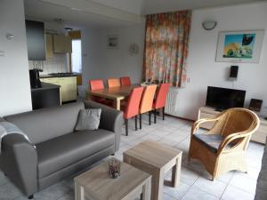 a living room with a couch and a table at Vakantiehuizen Hollandse Kust in Julianadorp