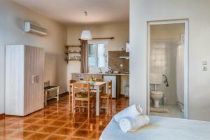 cocina y sala de estar con mesa y sillas en Lorraine's Apartments close to Lourdas Beach, en Cefalonia