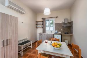 una cocina con una mesa con un bol de fruta. en Lorraine's Apartments close to Lourdas Beach, en Cefalonia
