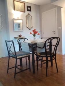 uma sala de jantar com uma mesa, cadeiras e um espelho em Il nido del Picchio 2 em Turim